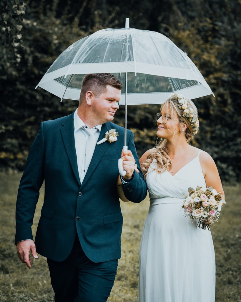 Ein Hochzeitspaar unter einem Regenschirm