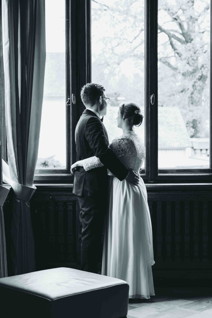 ein Hochzeitspaar vor einem Fenster