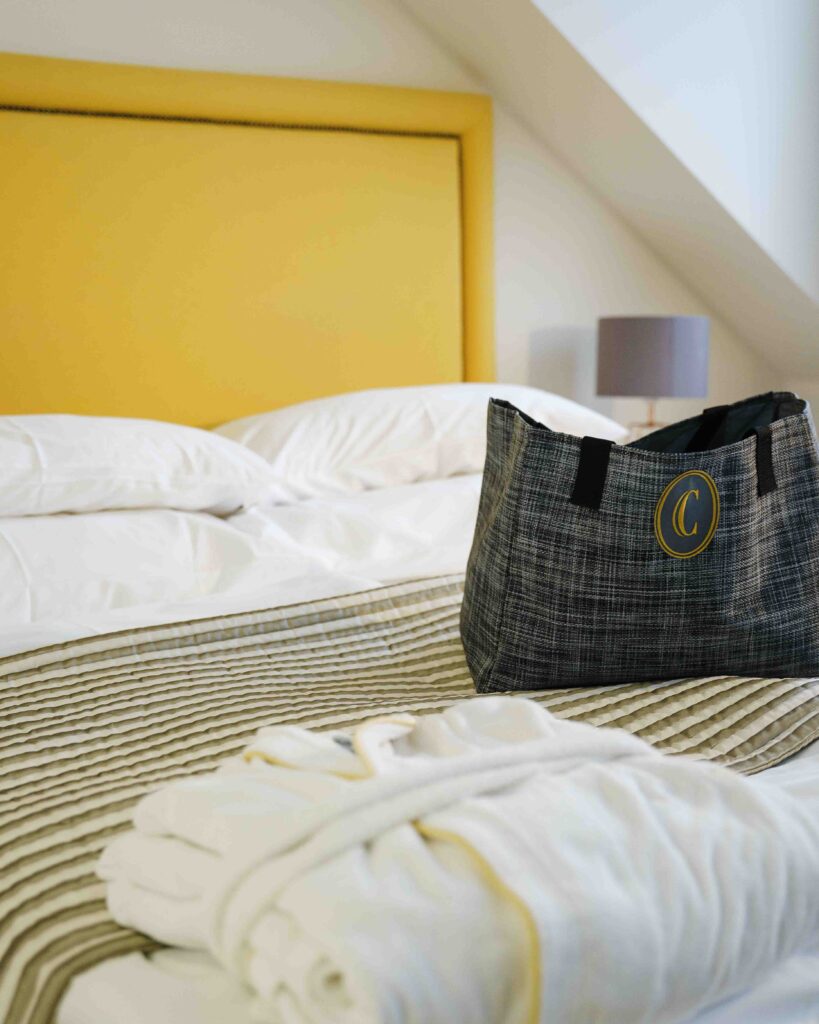 Bild von einer Tasche und einem Bademantel auf einem Bett in einem Hotel